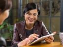 Two women using a tablet in a coffee shop