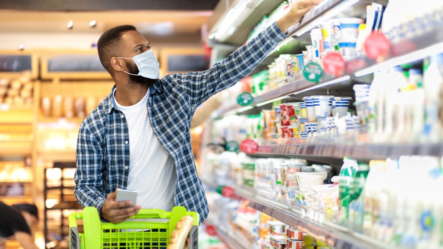 Black man grocery shopping in supermarket: trade promotion management