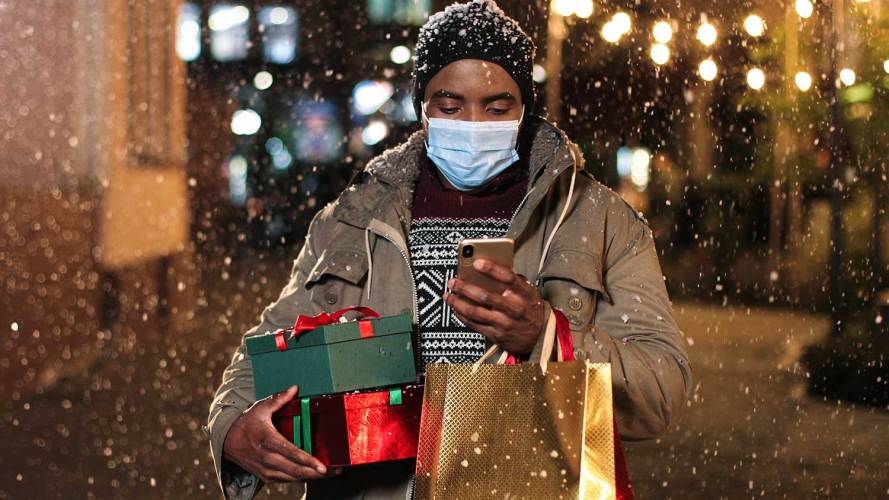 A man looks at his phone while holiday shopping.