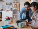 A photo showing a man and a woman looking at a laptop during the holidays. Holiday marketing.