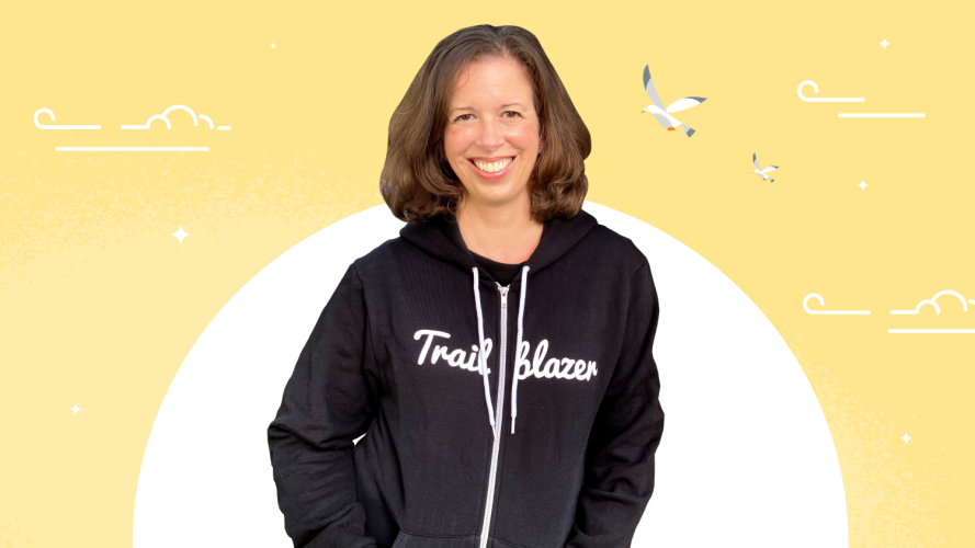 Trailblazer Kristen Clay in an iconic black hoodie stood against a bright yellow background