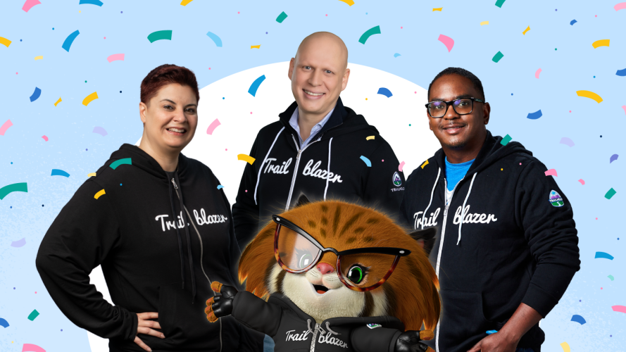 Three Trailblazers in iconic black hoodies stood behind Appy the Bobcat surrounded by confetti