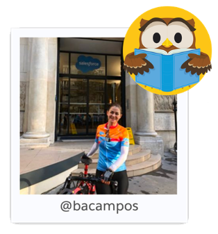 Instructor Barbara Campos with her bike outside the Salesforce tower. Hootie reading a book looks on. 