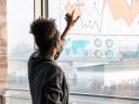 woman looking at a board with graphs and tables: data culture