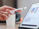 Hand holding a pen, pointing at a tablet with Tableau