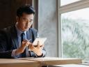 Man in suit looking at his smart tablet: insurance brokerage agency predictive analytics