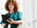 A woman in scrubs looks at a tablet. Healthcare ecommerce
