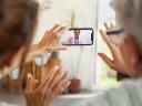 heteronormative couple is speaking over video with a man wearing a white lab coat via a smartphone: change management in health
