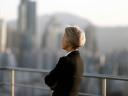 A business woman looking out over an outside city view. Corporate leaders.