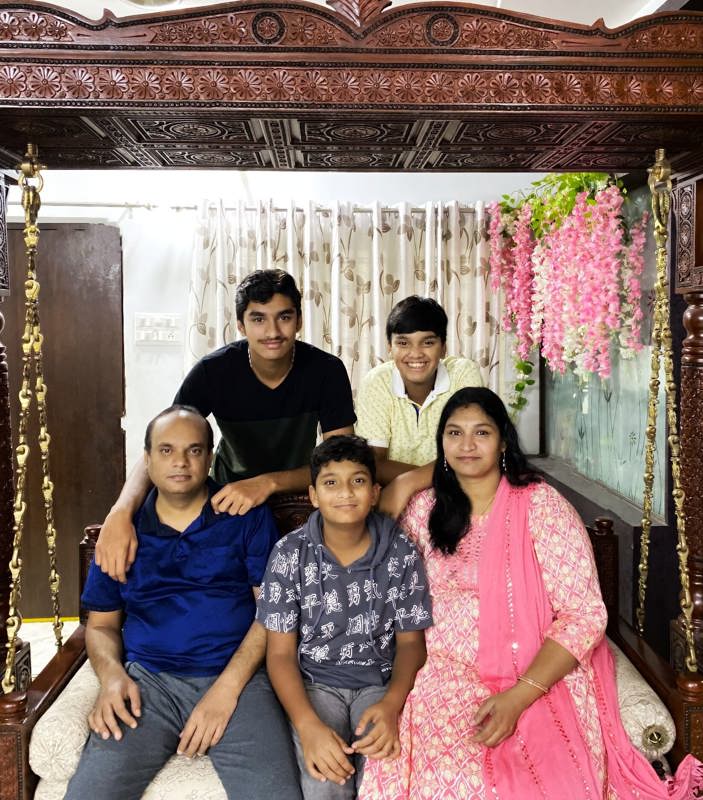 Chandrakala and her husband and her three sons smiling for a photo