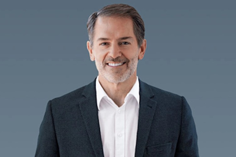 Photo of Jim professionally dressed smiling at the camera.