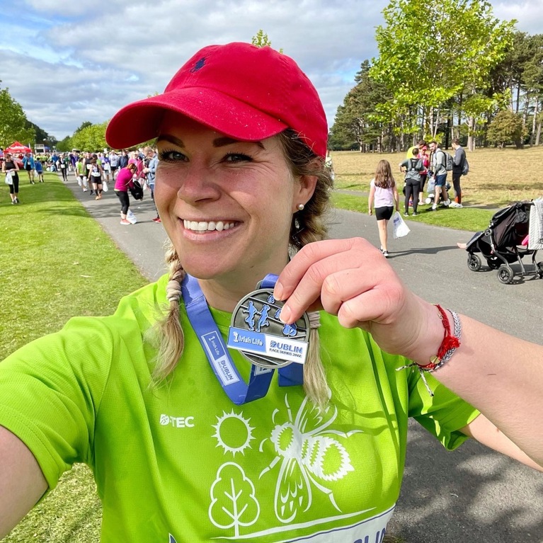Florine wearing a medal, after she participated in a half marathon