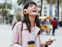 Person with headphones and a phone listening to the best business podcasts