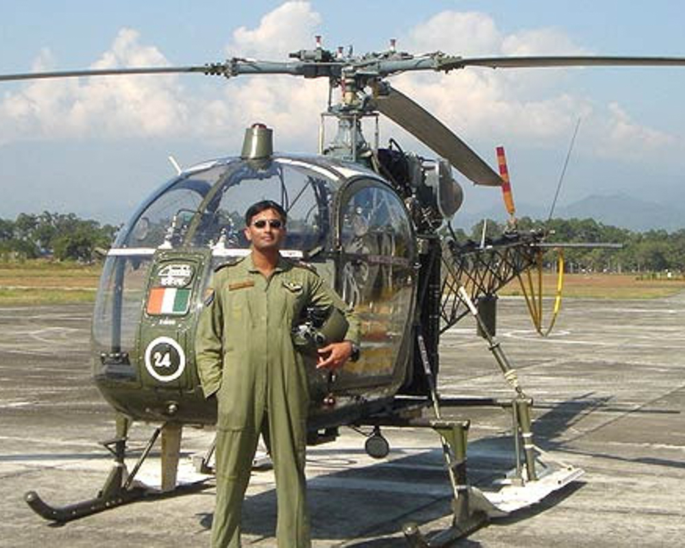 Gourav Ray wearing military uniform while standing in front of a helicopter