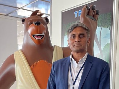 Gourav Ray standing next to Salesforce mascot Cody