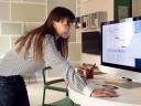Photo of a woman checking her schedule on a computer in an office / sandbox preview