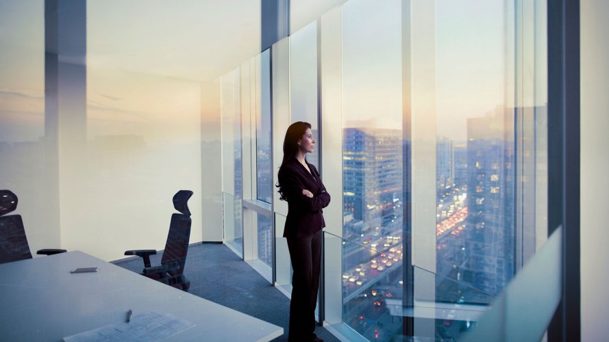 A woman who symbolizes the modern CFO looks out of a window in her office.