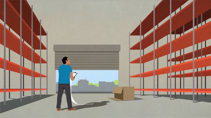 Man in blue shirt looking up at empty shelves in a warehouse, considering better supply chain management.