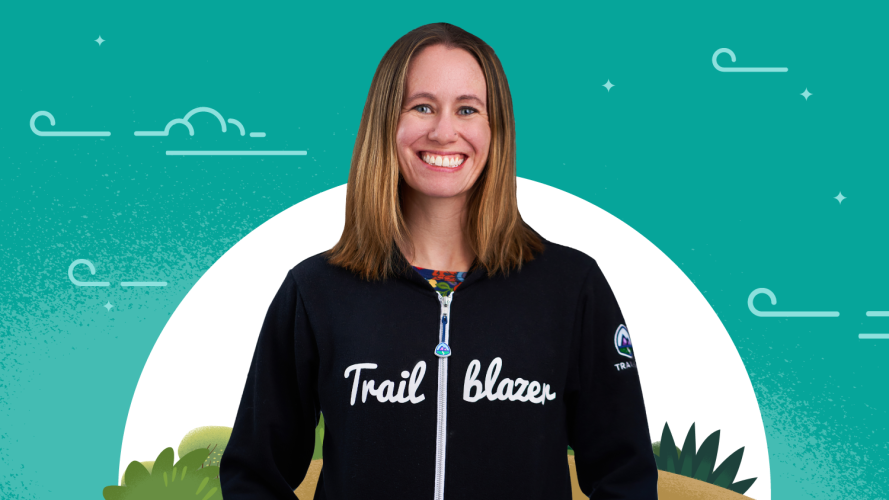 Photo of Trailblazer Katie Villanueva in her Trailblazer hoodie against a green sky background