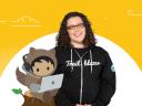Louise Lockie in a Trailblazer hoodie next to an illustrated Astro working on their laptop