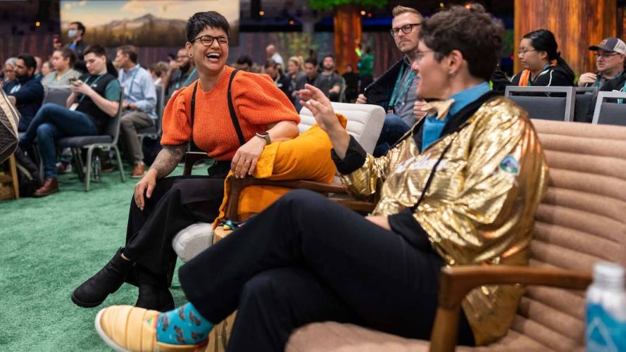 Attendees of the Salesforce Connection event, including one dressed in a gold Trailblazer jacket, discuss the latest panel