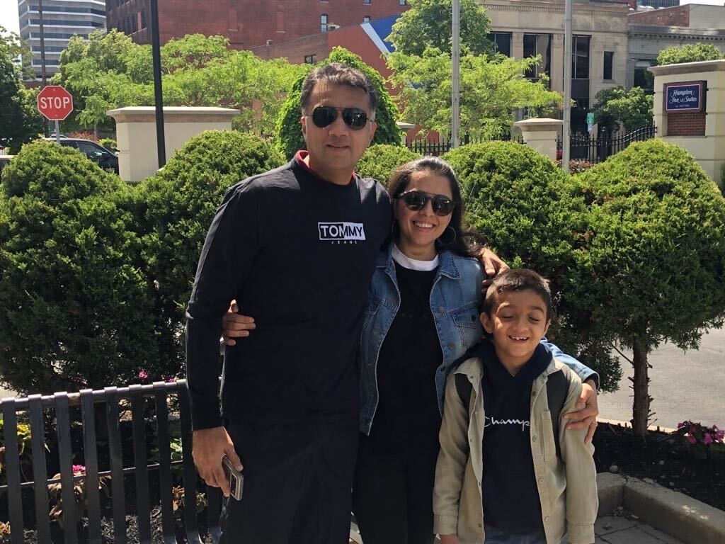 Aditi and her husband and son posing for a photo