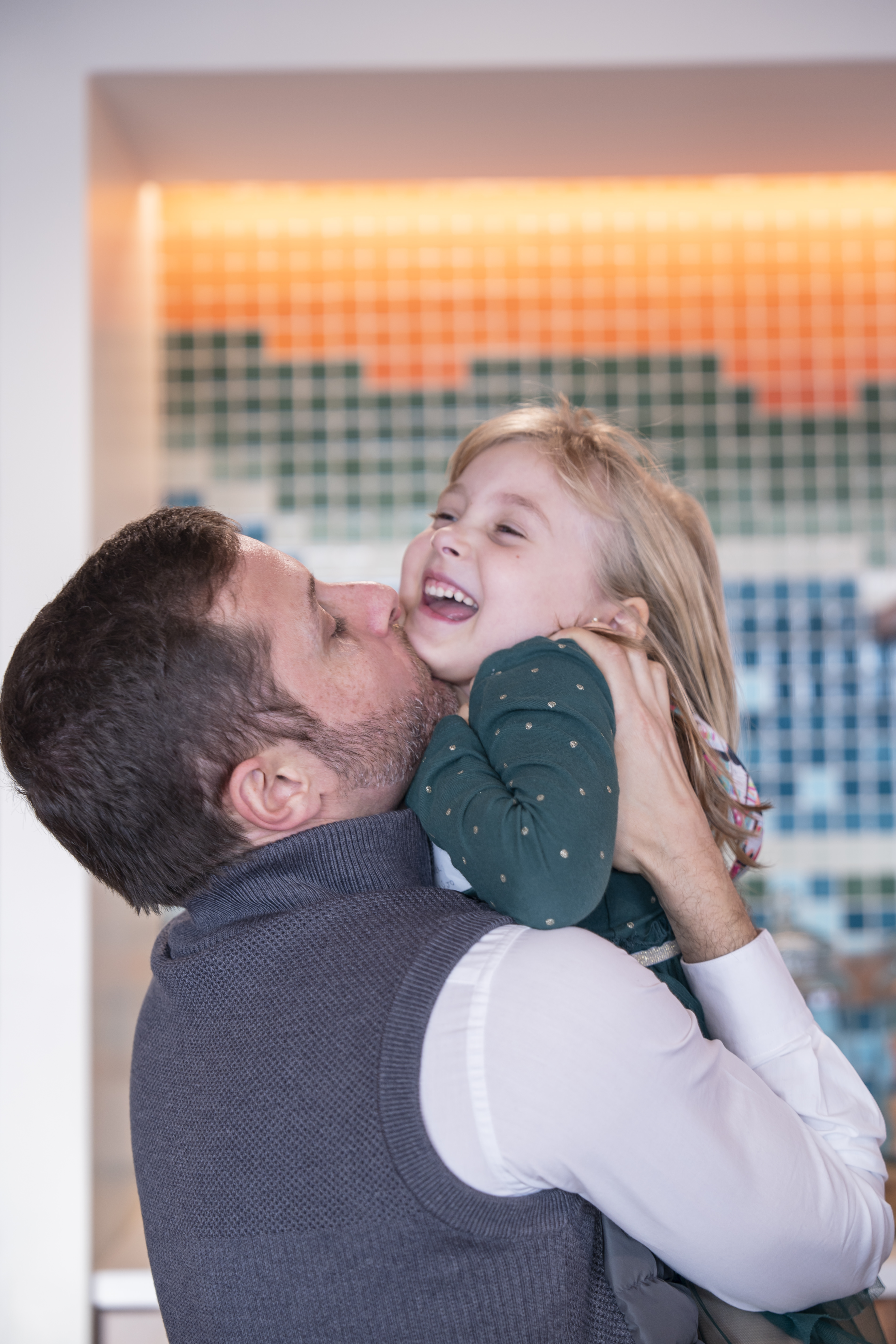 A man holding his daughter on his arms.