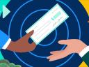 One man handing another man a check: sales compensation plans