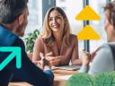 Three B2B salespeople sitting at a table talking and smiling