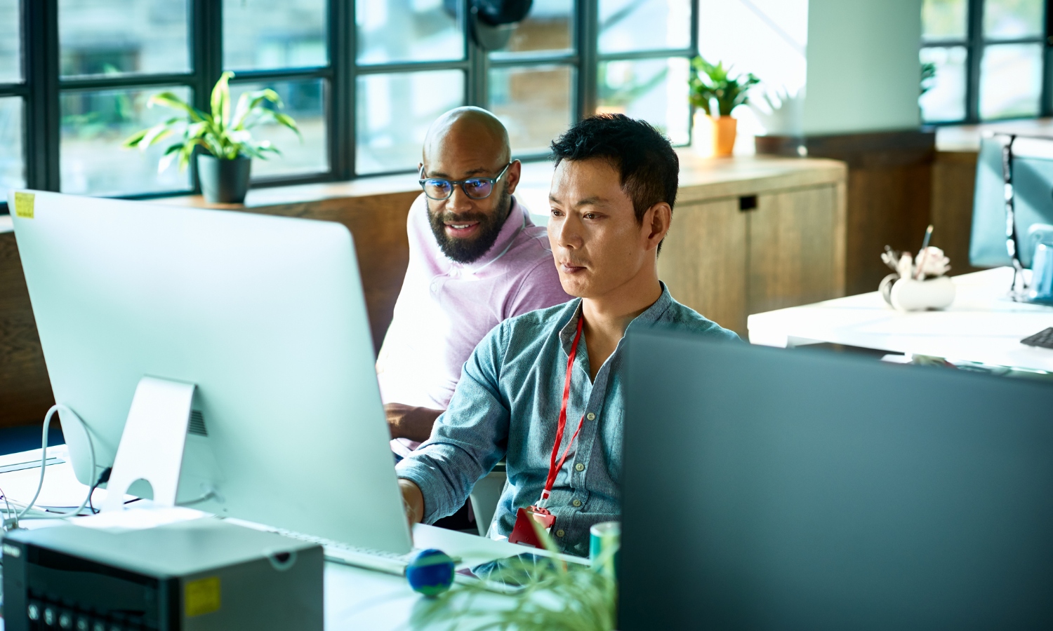 Computer programmer working with male colleague in office.