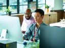 Computer programmer working with male colleague in office.