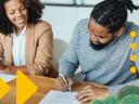 Two people sitting at a table and smiling during contract negotiation