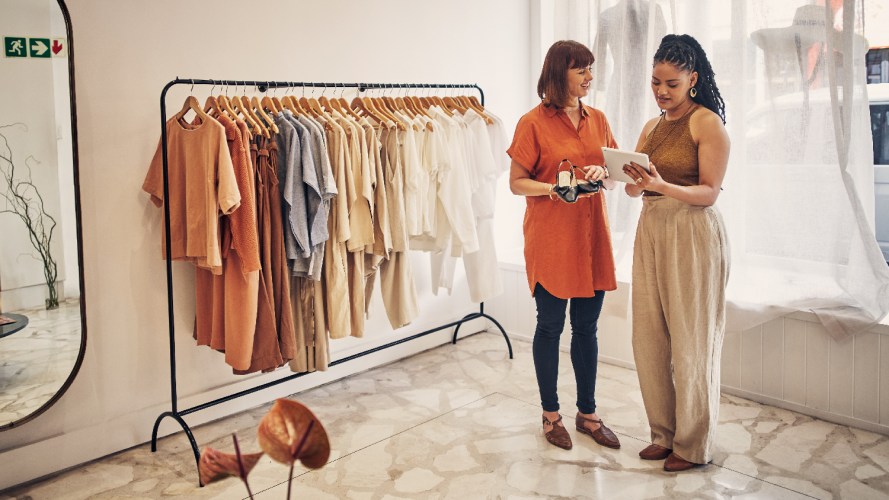 Photo of a saleswoman and a customer in a boutique clothing store, looking at a tablet / zero copy integration