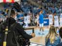 Photo of a cameraman working during a college basketball game / sports marketing
