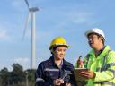 Two technicians in hard hats use technology to support field service sustainability.