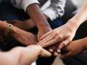 Image of a group of people putting their hands together / shared responsibility model