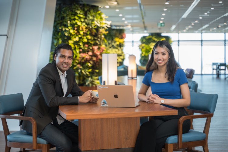 Two Salesforce employees sitting next to a laptop