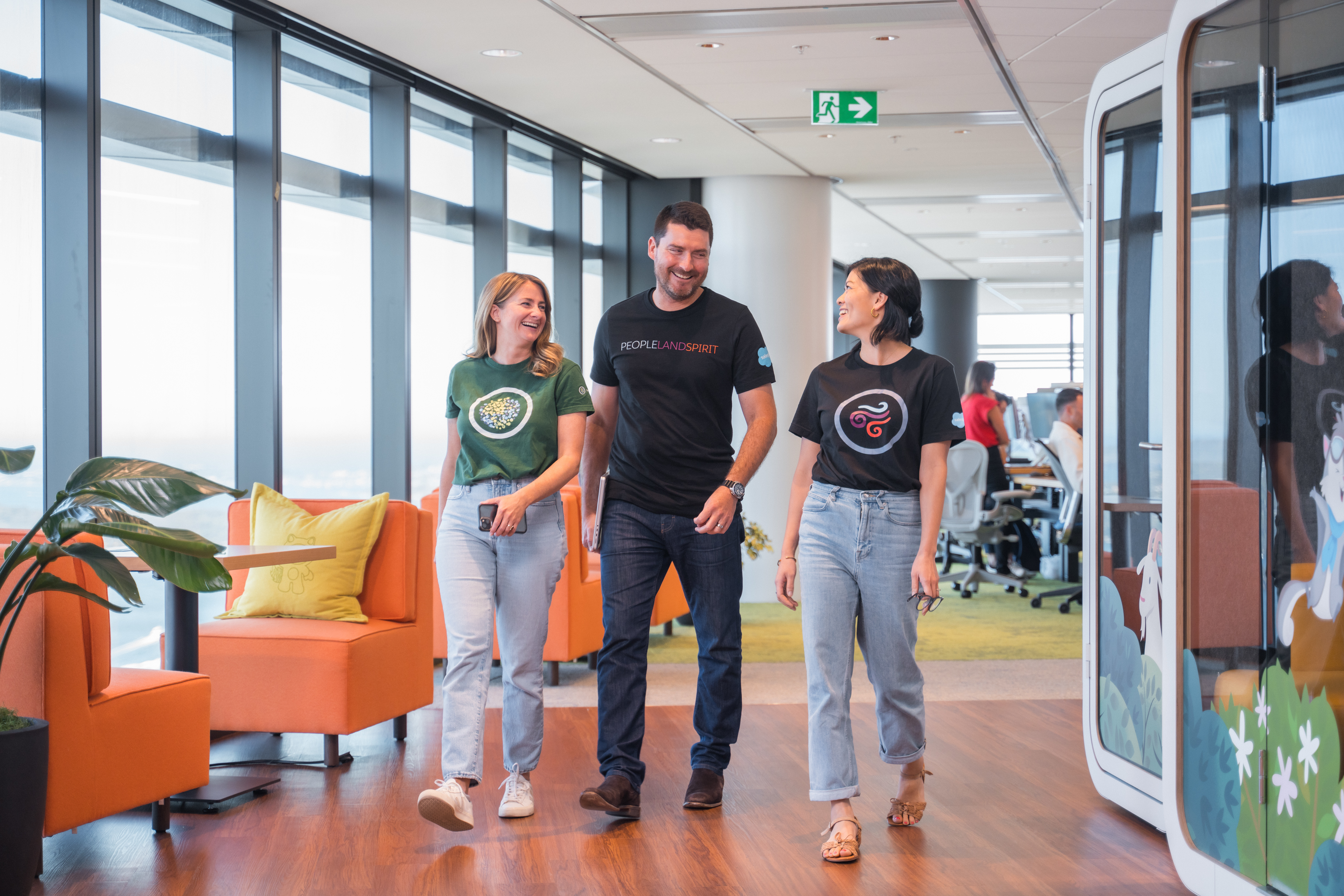 Three people smiling and chatting as they walk through the halls