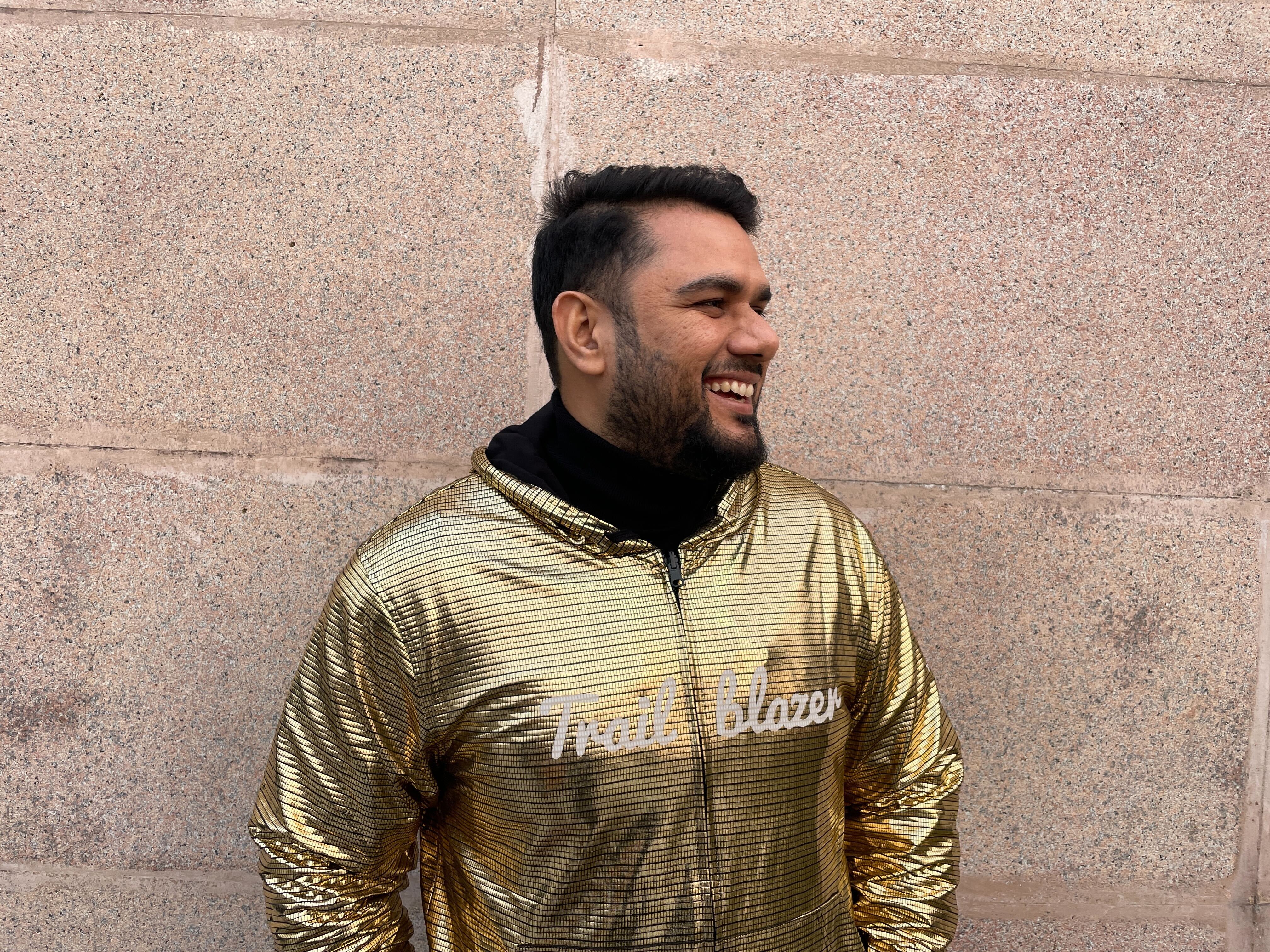 Photo of Yudhisther Yadav wearing a gold jacket that says "trailblazer"