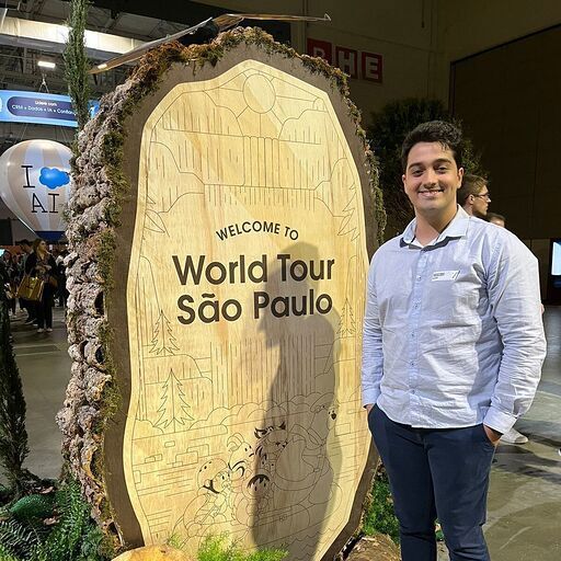 Vinicius standing next to a structure with the words " Welcome to World Tour Sao Paulo."