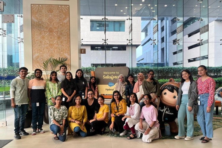 A group of interns pose together at the entrance of Salesforce India building