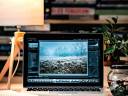 A cozy workspace featuring a laptop displaying a photo editing application.