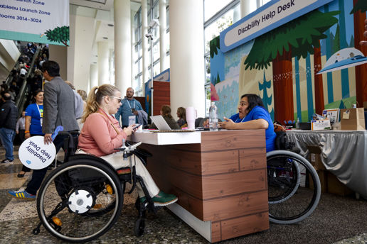Dreamforce attendee getting support at the disability help desk.