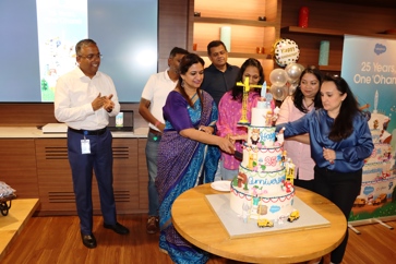 Salesforce India employees celebrating next to a cake.