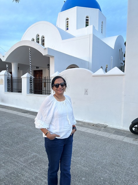 Saroja smiles and poses for a picture while standing on a street
