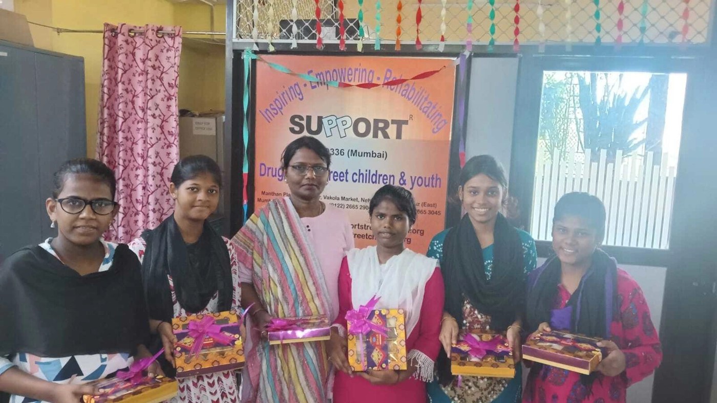 Salesforce India employees celebrating Diwali and posing together while holding presents in their hands.