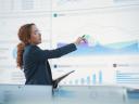 A woman pointing at charts on a whiteboard