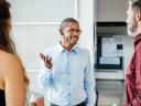 A business leader talking to two other employees.