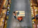 A warehouse worker using laptop to check location of goods.