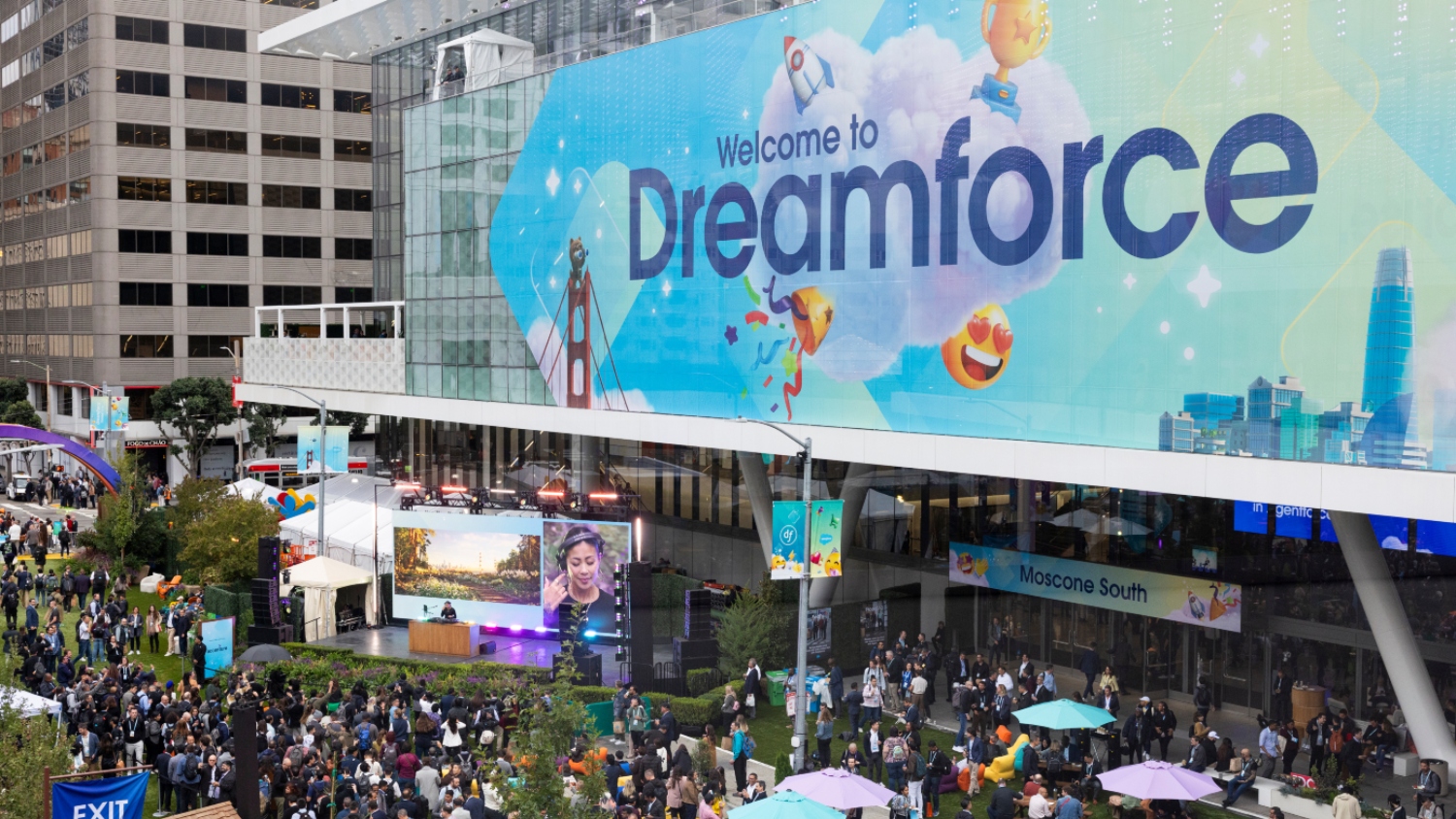 Aerial view of attendees gathered outside the Moscone Center under a Dreamforce conference entrance sign.